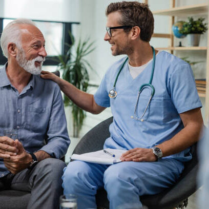 Happy doctor talking to senior male patient while being in a home visit.